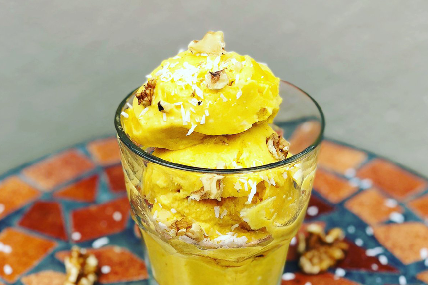 Mango turmeric ice cream in glass.