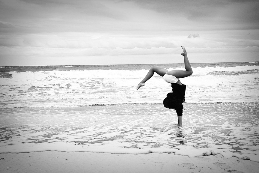 Woman doing yoga on the beach.