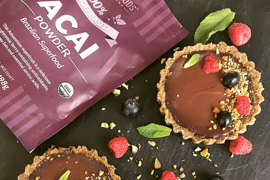 Two chocolate tarts with a bag of Acai 