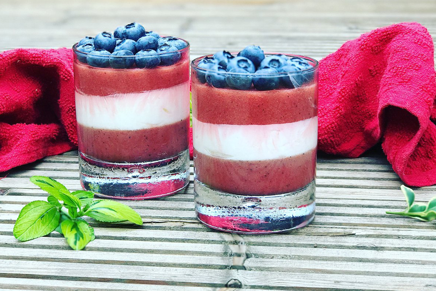 Two glasses with Sari Foods vegan berry pots in red, white, and blue.