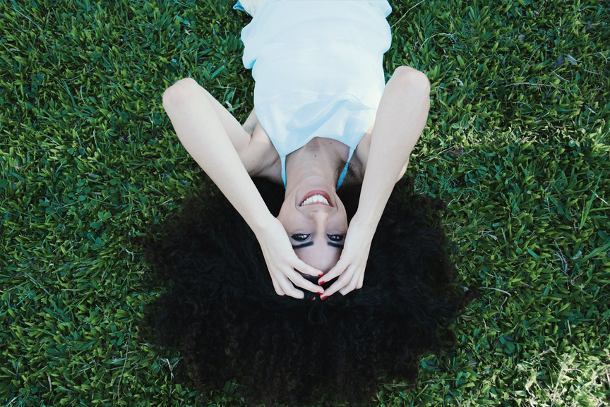 Woman laying on grass with her hair spread out