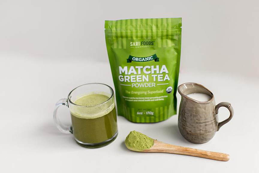 Matcha green tea latter in glass mug with milk pitcher