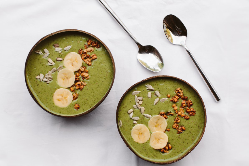 Green superfood smoothie bowls with spoons.