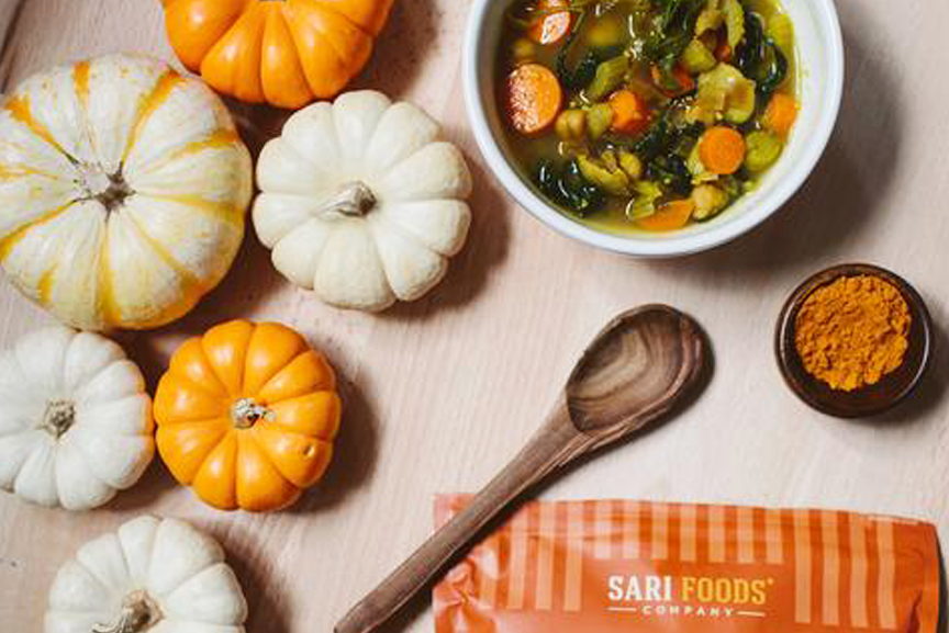 Warming Turmeric Soup with spoon and pumpkins