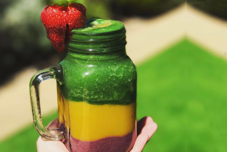 Three color smoothie in a jar with strawberry.