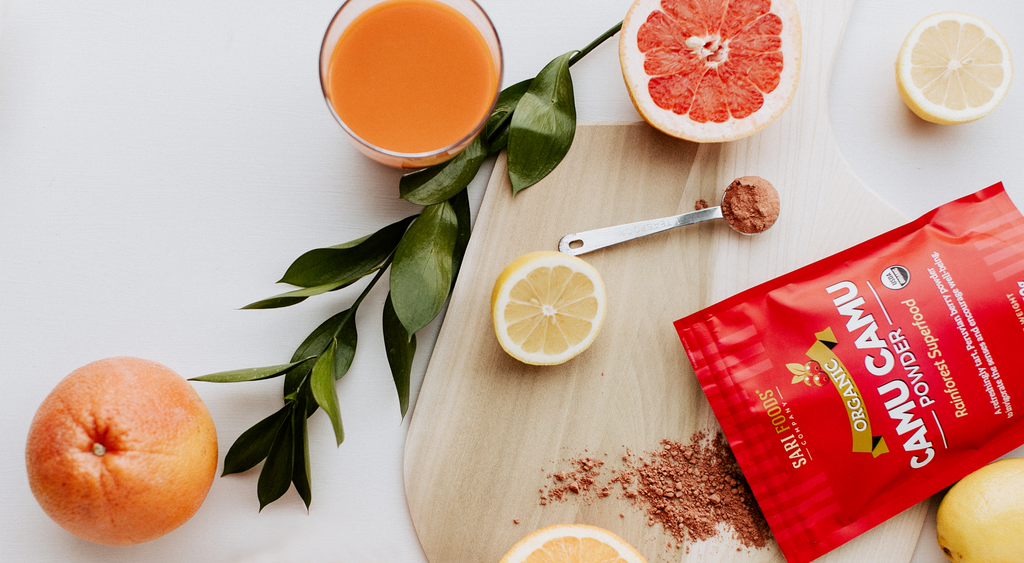 Camu Camu powder packaging and sliced citrus with juice.